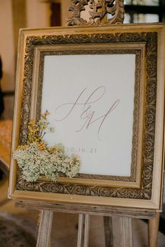 a wooden easer holding a sign with flowers on it