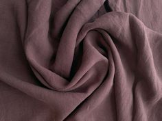 a close up view of a bed with purple sheets