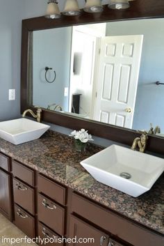 two white sinks sitting under a large mirror in a bathroom next to a sink counter