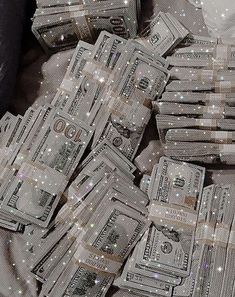 a pile of dollar bills sitting on top of a bed covered in glittery sheets