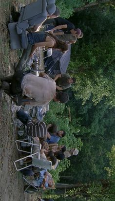 a group of people standing next to each other in front of some trees and grass