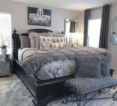 a large bed sitting in the middle of a bedroom next to a dresser and mirror