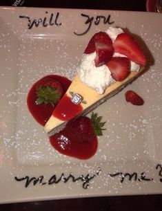 a piece of cheesecake with strawberries on it and the words will you marry me?