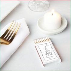 a white table topped with a candle and napkin