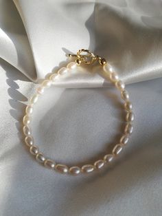 This Genuine Freshwater Pearl Bracelet/Modern Pearl Jewelry/Seed White Pearl Bracelet/Tiny Pearl Bracelet/Golden Toggle Pearl Bracelet is made with genuine seed freshwater pearl beads and a golden toggle. The pearl is rice-shaped, which creates a slim and modern feeling. The toggle adds more delicacy to it. This bracelet can be worn alone or be stacked with other golden bracelets to create a casual and modern feeling. It is a perfect gift for yourself or your loved ones. Domestic shipping is inc Elegant Charm Bracelet With Toggle Clasp, Classic Chain Bracelet With Toggle Clasp, Elegant Chain Bracelet With Lobster Clasp And Round Beads, Classic Pearl Charm Chain Bracelet As Gift, Everyday Gold Single Strand Pearl Bracelet, Classic Chain Bracelet With Pearl Charm As Gift, Gold Charm Bracelet Gift With Clasp, Elegant Gold Charm Bracelet With Clasp, Classic Everyday Bracelets With Toggle Clasp