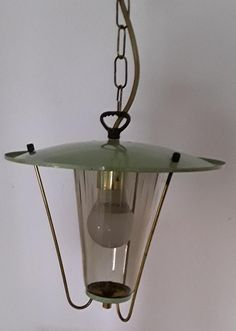 an old fashioned light hanging from a chain