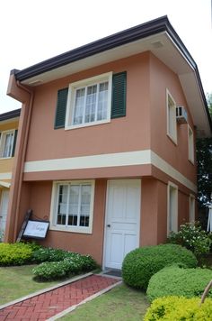 a house that is painted pink and has green shutters