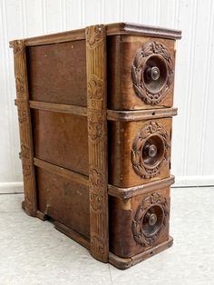 an old wooden chest with ornate carvings on the front and sides, sitting against a white wall