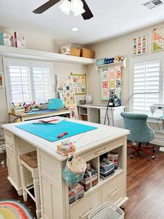 a sewing studio with lots of crafting supplies on the desk and in front of windows