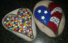 two heart shaped mosaics sitting on top of rocks