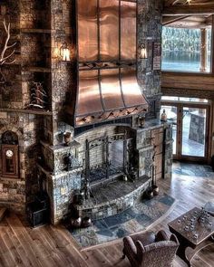 a living room filled with furniture and a fire place in the middle of a wooden floor