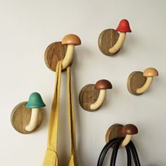 several mushrooms are mounted on the wall and hanging from hooks, along with two purses