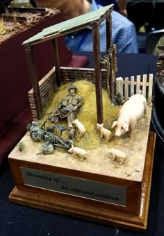 there is a small farm scene made out of wood and fake animals in the background