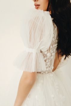 a woman in a white dress is posing for the camera