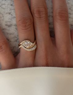 a woman's hand with a gold ring and diamond set on top of it