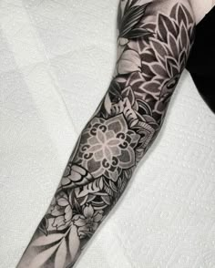 a black and white flower tattoo on the arm