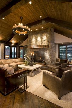 a living room filled with furniture and a fire place in the middle of an open floor plan