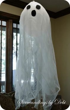 a ghost hanging from the ceiling in front of a window