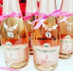 three bottles of champagne with pink bows on them