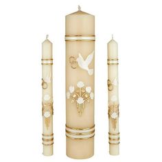 three candles with gold trimmings and doves on the top one candle is white