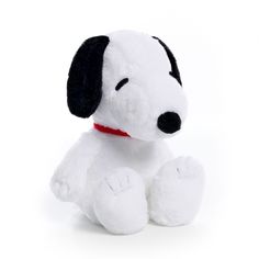 a white and black stuffed dog sitting on top of a white floor