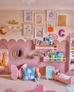 a child's bedroom with pink walls and pictures on the wall