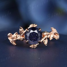 a blue diamond ring with leaves on it