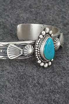 This Kingman turquoise and sterling silver bracelet was made by Navajo silversmith Michael Calladitto. The inside is signed MC and stamped Sterling.Size: 5 3/4" (will fit up to a 7 1/8" wrist)Gap: 1 3/8"Width: 1 1/8"Cuff Width: 1/2"Free shipping on all orders! We ship with USPS and always include tracking. All orders ship within a day of payment.Returns are accepted up to 30 days after you receive your order. Just send us a message. Our shop offers cash back or store credit. The item must be ret Stamped Turquoise Bracelet, Handmade Western Turquoise Bracelets, Handmade Western Turquoise Bracelet, Turquoise Stamped Bracelet, Handmade Western Style Turquoise Bracelet, Western Turquoise Bracelet With Concho, Handmade Western Sterling Silver Cuff Bracelet, Western Turquoise Bracelets With Concho, Bohemian Engraved Turquoise Sterling Silver Bracelet