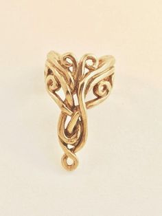 The intricate design of this 14K gold Arabesque Ear Cuff is both classic and exotic. The Arabesque Ear Cuff is 7/8" long, comfortable and easy to wear and it fits both the left and the right ears.  Diamond not included.  Our ear cuffs require no piercings. Starting near the top of the ear, simply slide the cuff down along the edge of the ear's cartilage. If minor adjustments are needed, you may gently open or close the opening of the ear cuff to accommodate the thickness of your ear using a pair Yellow Gold Brass Ear Cuff, Elegant Yellow Gold Jewelry With Artistic Design, Unique Gold Brass Ear Cuff, Elegant Gold Brass Ear Cuff, Modern Twist Brass Jewelry In Gold Color, Modern Twist Gold Brass Jewelry, Gold 14k Wedding Ear Cuff, Unique Gold Ear Cuff, Elegant Adjustable Gold Ear Cuff