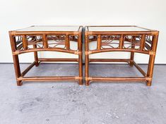 pair of bamboo and glass side tables on concrete floor with white wall in the background