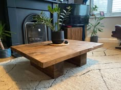 a wooden table sitting on top of a rug next to a fire place in a living room