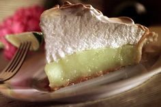 a piece of pie sitting on top of a white plate next to a pink flower