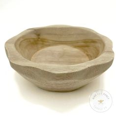 a wooden bowl sitting on top of a white table