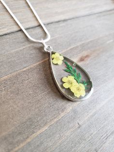 Beautiful real dried yellow garden flower pendant made from preserved yellow flower petals in resin in a vibrant silver teardrop. Elegant yellow and green flower necklace on 925 sterling silver plated stainless steel necklace chain. Natural dried flower jewelry piece ♥ Please note that every flower is different as found in nature Be sure to check out the NECKLACE section at EarringsbyLCreations for all kinds of necklaces available! https://www.etsy.com/shop/EarringsByLCreations?section_id=250342 Silver Hypoallergenic Flower Necklace, Silver Nature-inspired Jewelry With Pressed Flowers, Nature-inspired Silver Jewelry With Pressed Flowers, Teardrop Pressed Flowers Jewelry Gift, Teardrop Necklace With Natural Inclusions For Gift, Teardrop Jewelry With Pressed Flowers, Teardrop Pendant Jewelry With Flower Charm As A Gift, Silver Teardrop Jewelry With Flower Charm, Sterling Silver Flower Jewelry With Pressed Flowers