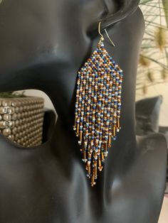 Beaded Fringe Earrings. Multi coloured in shades of blue, bronze, off white, brown and gold. Artisan Multicolor Beaded Earrings With Gold Beads, Traditional Multicolor Beaded Earrings With Gold Beads, Multicolor Beaded Earrings With Gold Beads As Gift, Artisan Blue Beaded Earrings With Colorful Beads, Handmade Bronze Beaded Earrings With Round Beads, Handmade Bronze Beaded Earrings, Artisan Blue Earrings With Dangling Beads, Gold Artisan Beaded Earrings With Dangling Beads, Bohemian Blue Earrings With Gold Beads