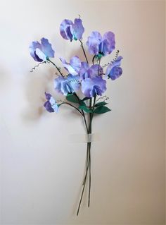 a bunch of blue flowers on a white wall