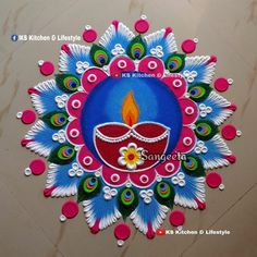 colorful diya with peacock feathers on it and a lit candle in the center, surrounded by dots