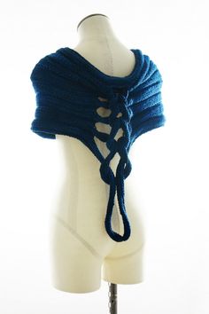 a white mannequin wearing a blue knitted shawl