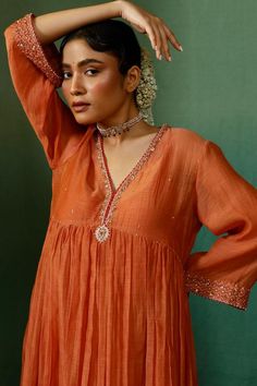 Rust orange malai cotton dress with gathered flare, contrast thread, zari, bead, sequin embroidered yoke and bell sleeves. Paired with inner slip.
Components: 2
Pattern: Embroidered
Type Of Work: Sequin, Zari, Thread and Bead Work
Neckline: V Neck
Sleeve Type: Dress: Bell Sleeves, Inner Slip: Sleeveless
Fabric: Malai Cotton
Color: Orange
Other Details: 
Contrast hem details
Occasion: Mehendi and Haldi - Aza Fashions Cotton Silk Straight Kurta With Gota Work, Cotton Dress With Gota Work, Orange Cotton Dress For Festivals, Orange Traditional Dress With Chikankari Embroidery, Orange Chikankari Embroidered Dress For Festivals, Orange Gota Work Dress For Festivals, Orange Dress With Gota Work For Festivals, Orange Anarkali Dress For Festive Season, Traditional Orange Dress With Dupatta