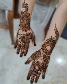 two hands with henna tattoos on them