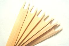 six wooden utensils lined up on a white surface