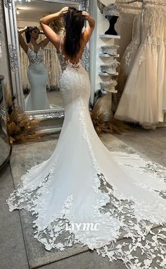 a woman is looking at her wedding dress in the mirror