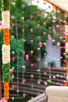 an outdoor ceremony with flowers hanging from the ceiling