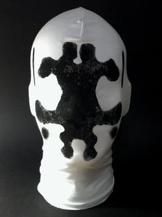 a white mask with black designs on it's face is shown in the image