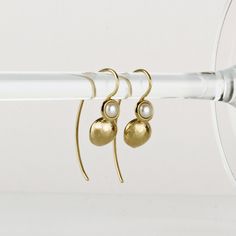 Delicate gold pearl earrings, handmade of yellow 14k solid gold and small round white freshwater pearls. The earrings have an organic feel, they are shiny and comfortable to wear. Classy and timeless, these gold earrings will add a fine soft touch to any outfit. They can be a perfect match for a pearl necklace, or a gold necklace. A wonderful gift for yourself or for someone you love. Total length of these earrings is approx. 2.9 cm = 1.14 inch (including ear wire) Length of the earring without the ear wire is 1.33 cm = 0.5 inch Pearl is about 3 mm in diameter = about 0.11 inch Silicone ear backs are included for safety. * The earrings will be packed in a gift box ready to give as a gift, and shipped via Express mail service which usually takes 4-6 business days to arrive. * For more gold Dainty Brass Pearl Drop Earrings, Elegant Brass Pearl Earrings, Elegant Hammered Round Earrings, Elegant Round Brass Pearl Earrings, Elegant Hand Forged Pearl Earrings For Gift, Yellow Gold Pearl Drop Earrings In Brass, Sterling Silver Yellow Gold Earrings With Pearl Charm, Yellow Gold Brass Pearl Earrings, Yellow Gold Sterling Silver Earrings With Pearl Charm