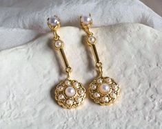 Discover the charm of our exquisite bridal earrings, featuring a delicate blend of gold and baroque pearls. These small yet elegant dangling studs are designed to complement your bridal ensemble with a touch of refined luxury. Crafted with care, these earrings offer a subtle glow that enhances your natural beauty without overpowering it. The combination of gold and baroque pearls brings a timeless elegance to your look, making them perfect for the bride who appreciates understated sophistication. Whether you're walking down the aisle or celebrating at a special event, these earrings are designed to add a gentle, sophisticated sparkle to your attire. Their classic design and delicate detailing make them a beautiful choice for any bride who desires a touch of grace and elegance. Celebrate yo Gold Pearl Charm Earrings For Wedding, Gold Pearl Embellished Earrings For Wedding, Delicate Yellow Gold Bridal Earrings With Pearl Drop, Elegant Yellow Gold Bridal Earrings, Delicate Yellow Gold Bridal Earrings For Wedding, Victorian Pearl Earrings For Wedding, Yellow Gold Dangle Bridal Earrings For Wedding, Gold Delicate Bridal Earrings For Wedding, Delicate Gold Bridal Earrings For Wedding