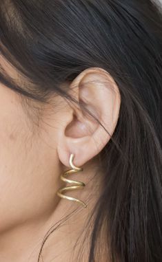 EARRINGS WITH A TWIST WHAT IT IS: Gold spiral earrings WHY IT’S SPECIAL: We love the unique shape that grabs attention, but sits comfortably on your ear The spiral is used here as a representation of positive energy Handmade in St. Louis by emerging black designer Shayba Muhammad GOOD TO KNOW: Length: 1 3/8” in Width: 3/4" in Gold plated brass Sterling silver earring backs WHY WE LOVE MAHNAL: This black, female-owned brand, epitomizes what we love in a designer—creativity and culture. The modern Modern Wrap Earrings For Pierced Ears As Gift, Spiral Earrings With A Modern Twist, Modern Twist Spiral Wrap Earrings As Gift, Modern Swirl Earrings For Gift, Modern Twist Spiral Wrap Earrings, Spiral Single Earring As Gift, Spiral Single Earring Gift, Unique Spiral Wrap Earrings For Gift, Unique Spiral Wrap Earrings As Gift