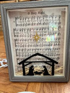 a framed nativity scene with the birth of jesus and baby jesus in manger