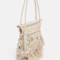 a white bag with tassels hanging from it