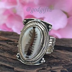 This stunning Cowrie Shell Gemstone Ring is made of polished, textured, and oxidized sterling silver with a handcrafted sterling silver ring setting. The ring has a beautiful and unique design with a high polish that gives the ring a luxe look. This friendship Gift is perfect for everyday wear and is sure to be a conversation starter. Metal : 925 Sterling Silver Weight (Gms) : 9 Gms Approx Style : Cocktail Ring Size :  All Sizes Healing Properties : ------------------------------------------------------------------------------------ The cowrie shell has many uses and meanings. ... Spiritually, according to African legend, if you are attracted to cowrie shells you could be family to an Ocean Spirit of wealth and earth. It also represents Goddess protection which is very powerful and connect Handmade Bohemian Ring For Anniversary, Bohemian Handmade Rings For Anniversary, Bohemian Carved Sterling Silver Jewelry, Bohemian Engraved Toe Ring, Bohemian Engraved Rings As Gift, Bohemian Engraved Open Ring, Bohemian 925 Stamped Toe Rings, Bohemian Rings With Oxidized Finish For Anniversary, Bohemian Sterling Silver Ring With Oxidized Finish